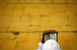 Indonesia Prints: A student reads the Koran before morning prayer on the holy month of Ramadan