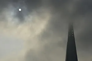 The sun begins to shine through morning fog next to the Shard in central London