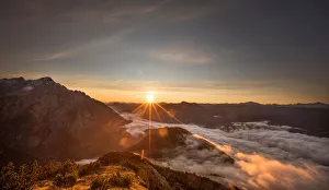 The sun rises over mountain summits in the Austrian village of Absam