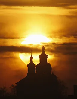The sun rises above an Orthodox Church in the town of Novogrudok