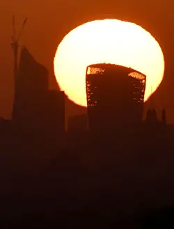Weather Prints: The sun is seen rising over skyscrapers in the City of London financial district in