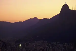 The sun sets behind Christ the Redeemer statue on Corcovado mountain in Rio de Janeiro