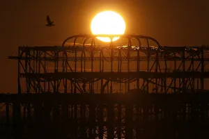 United Kingdom Prints: The sun sets behind the old West Pier in Brighton, southern England
