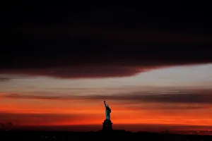 Images Dated 2018 May: The sun sets behind the Statue of Liberty after a rain storm in New York