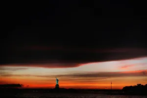 Images Dated 2018 May: The sun sets behind the Statue of Liberty after a rain storm in New York