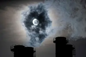 Sun shines through steam rising from chimneys of a power plant in Moscow