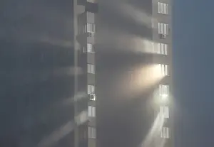 Sunlight reflects from windows of an apartment building on a foggy autumn day in Kiev