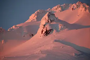 : At sunset, climbers and rescue personnel descend Mount Hood