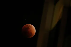 A super blood blue moon is seen during an eclipse, behind an office building in Hong A super blood blue moon is seen during an eclipse, behind an office building in Hong