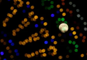Sighting Prints: The supermoon full moon is seen through Christmas lights in Valletta