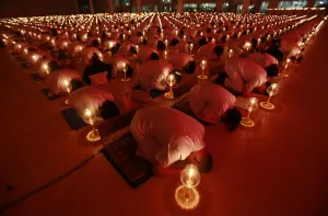 Thailand Prints: Thousands of Thais and Buddhist monks light candles as they pray for Japans earthquake