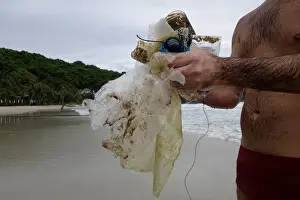 Environment Prints: Tourist collects plastic items washed up by the sea at the Ao Phrao Beach