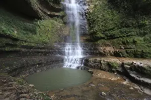 A tourist lies down near a waterfall at the Juan Curi natural park near the municipality