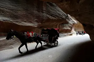 Transport Prints: Tourists ride a horse-drawn cart during a tour in the ancient city of Petra