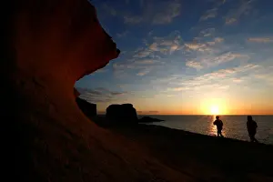 Prints of Tourists walk near eroded limestone rock formations at Dwejra outside the village of San Lawrenz on the island of Gozo, Malta, January 25, 2018. REUTERS/Darrin Zammit Lupi Global Prints: Tourists walk near eroded limestone rock formations at Dwejra outside the village of San