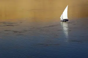 Traditional Egyptian Felucca boat sails on the Nile river in the southern Egyptian