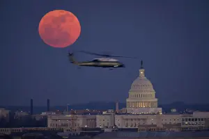 A U. S. Marine Corps helicopter is seen flying through this scene of the full Moon and the U