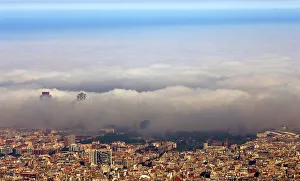 An unusual fog settles over Barcelonas city coastline