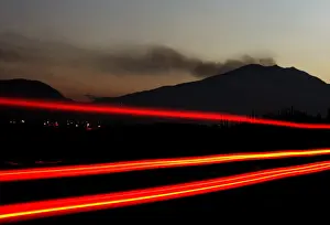 A vehicle passes along a highway as smoke is emitted from the Galeras volcano in Chachagui
