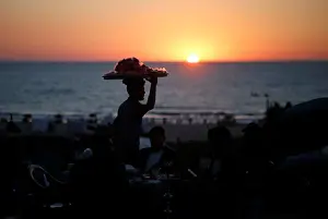 Prints of A vendor sells candied apples during the sunset on the beach in Gaza City July 2, 2019. Picture taken July 2, 2019. REUTERS/Mohammed Salem Israel Prints: A vendor sells candied apples during the sunset on the beach in Gaza City