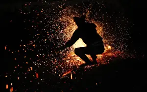 A Vietnamese man from the Pa Then minority group jumps into a fire during a ritual