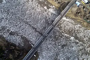 A view shows vehicles driving along a bridge across the Mana River during an ice drift