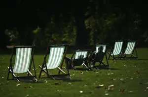United Kingdom Prints: Visitors enjoy the autumn sunshine as they sit in deck chairs in St James Park, central