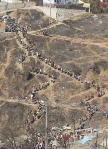 Chile Prints: Volunteers form a line as they pass down debris from burned houses after a fire burned