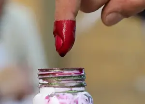 : A voters finger is marked with ink at a polling station during the second day of