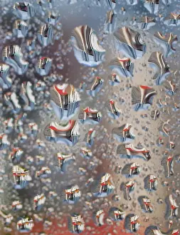 Water droplets on a window reflect Housing Development Board apartment flats in Singapore