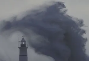 Britain Prints: Waves and high winds hit the sea wall and light beacon at Newhaven in south England