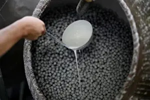 White chocolate is poured on chocolate filled candies in La Giralda chocolate factory