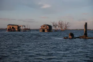 Climate Prints: The Wider Image: Rising seas threaten early end for sinking village in Philippines