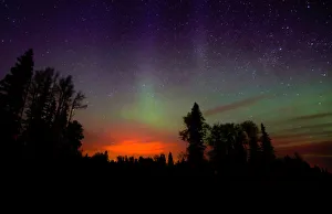 The wildfires glow underneath The Northern Lights, also known as the Aurora Borealis