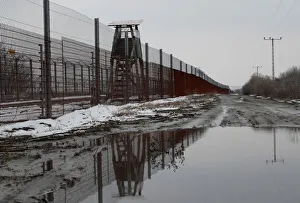 Election Prints: A wire fence is seen next to the village of Asotthalom