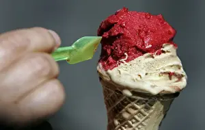 Food And Drink Prints: A woman enjoys an ice cream outside Giolitti ice-cream shop in downtown Rome