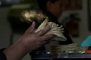 Mexico Prints: Woman holds freshly made corn tortillas at a tortilla factory in Mexico City