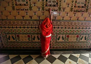 India Prints: A woman prays as she touches the wall of a temple during Navratri festival in Kolkata