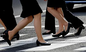 Women in high heels walk at a business district in Tokyo