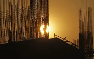 A worker arranges steel structures at construction site of apartment in Hanoi