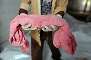 Worker holds the body of an unborn baby whose mother was killed by an airstrike in