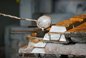 A worker takes a sample of molten alumnium in a shop of Kazakh mining company Eurasian
