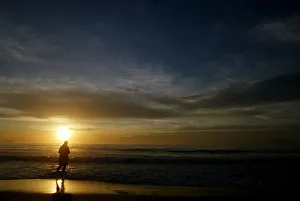 Prints of A worshipper tosses a floral offering for Iemanja, the Goddess of the sea, during sunrise on Copacabana beach in Rio de Janeiro, December 31, 2005 Brazil Prints: Worshipper tosses floral offering for Goddess of the sea, during sunrise on Copacabana