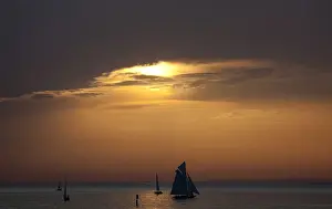 Austria Prints: Yachts are silhouetted as sun sets over Lake Constance in Bregenz
