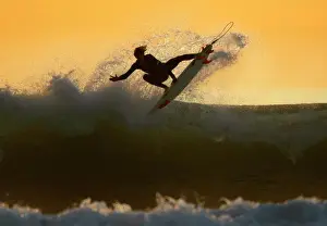 Young surfer sails his board off a wave as large swells hit the California coastline
